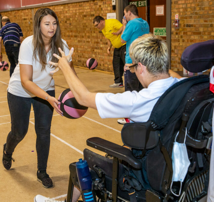 Living-2 Coach supporting participant during accessible basketball session