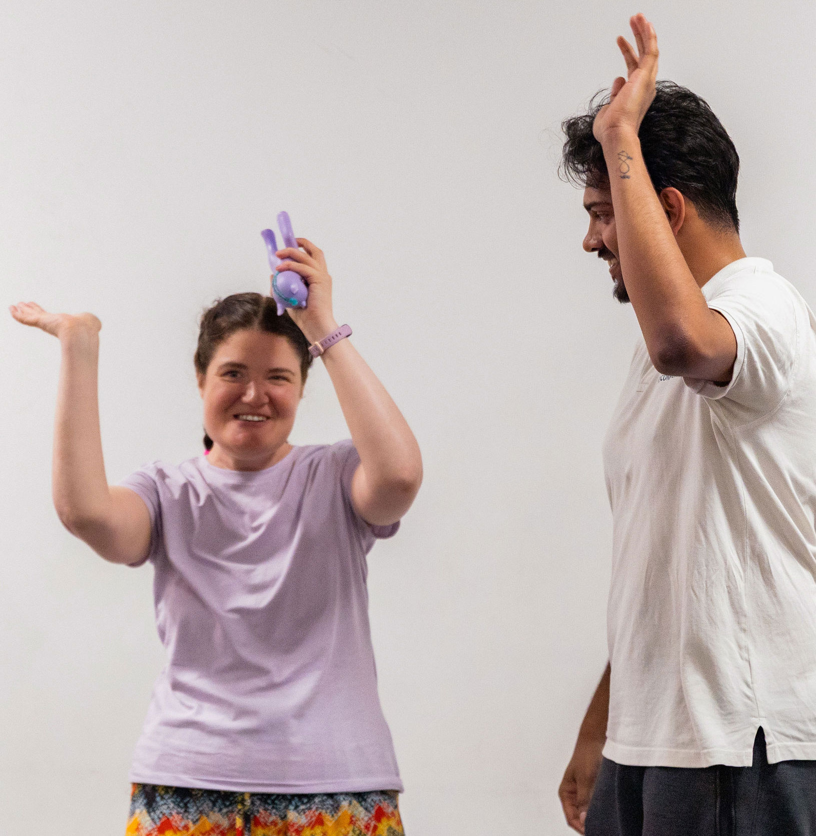 Smiling woman and man standing with their arms in the air
