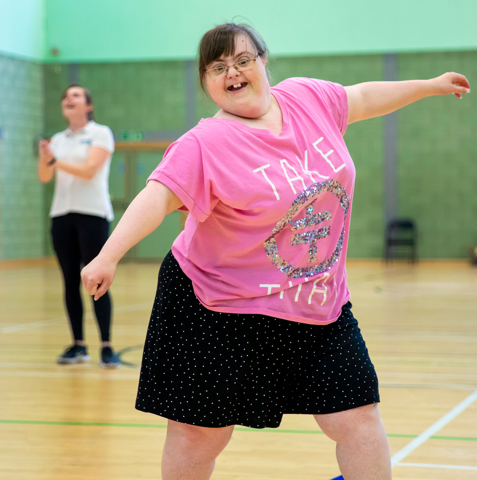 Smiling girl in a sports hall with outstretched arms