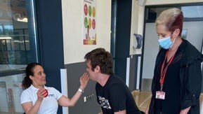 Support worker communicating with participant during an indoor activity session