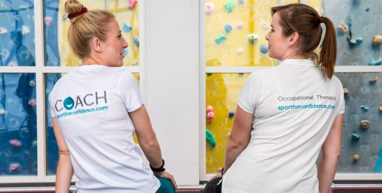 Sport for Confidence coach and occupational therapist talking at an indoor climbing centre