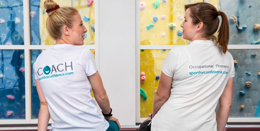 Sport for Confidence coach and occupational therapist talking at an indoor climbing centre