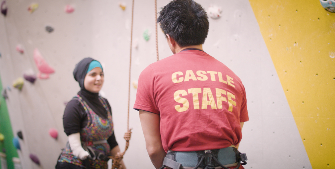 Participant speaking with climbing staff at an indoor climbing wall