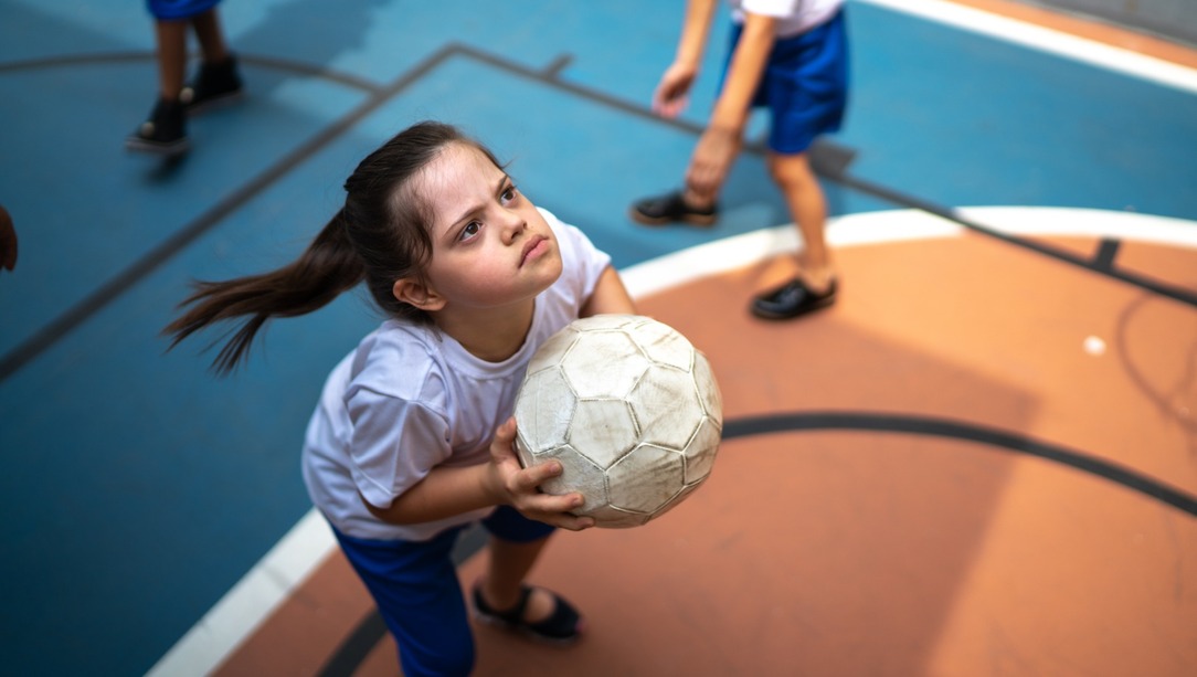 Child holding a ball during an inclusive school sports activity