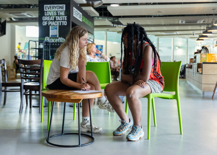 Two people filling in a form in a coffee shop