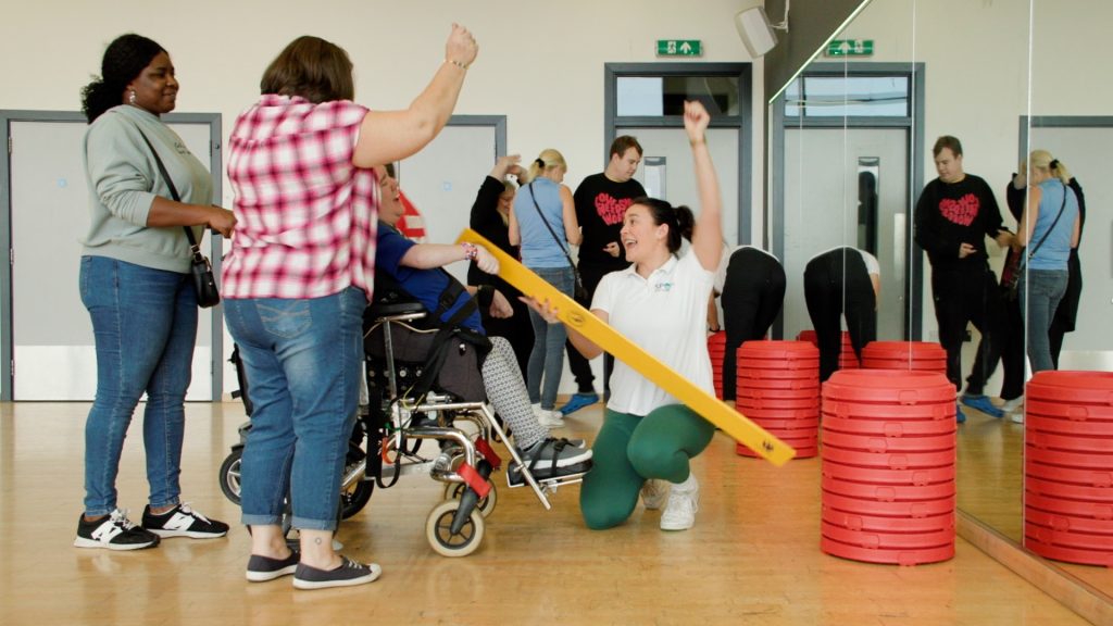 A Sport for Confidence occupational therapist supports participants to play an inclusive game of Boccia